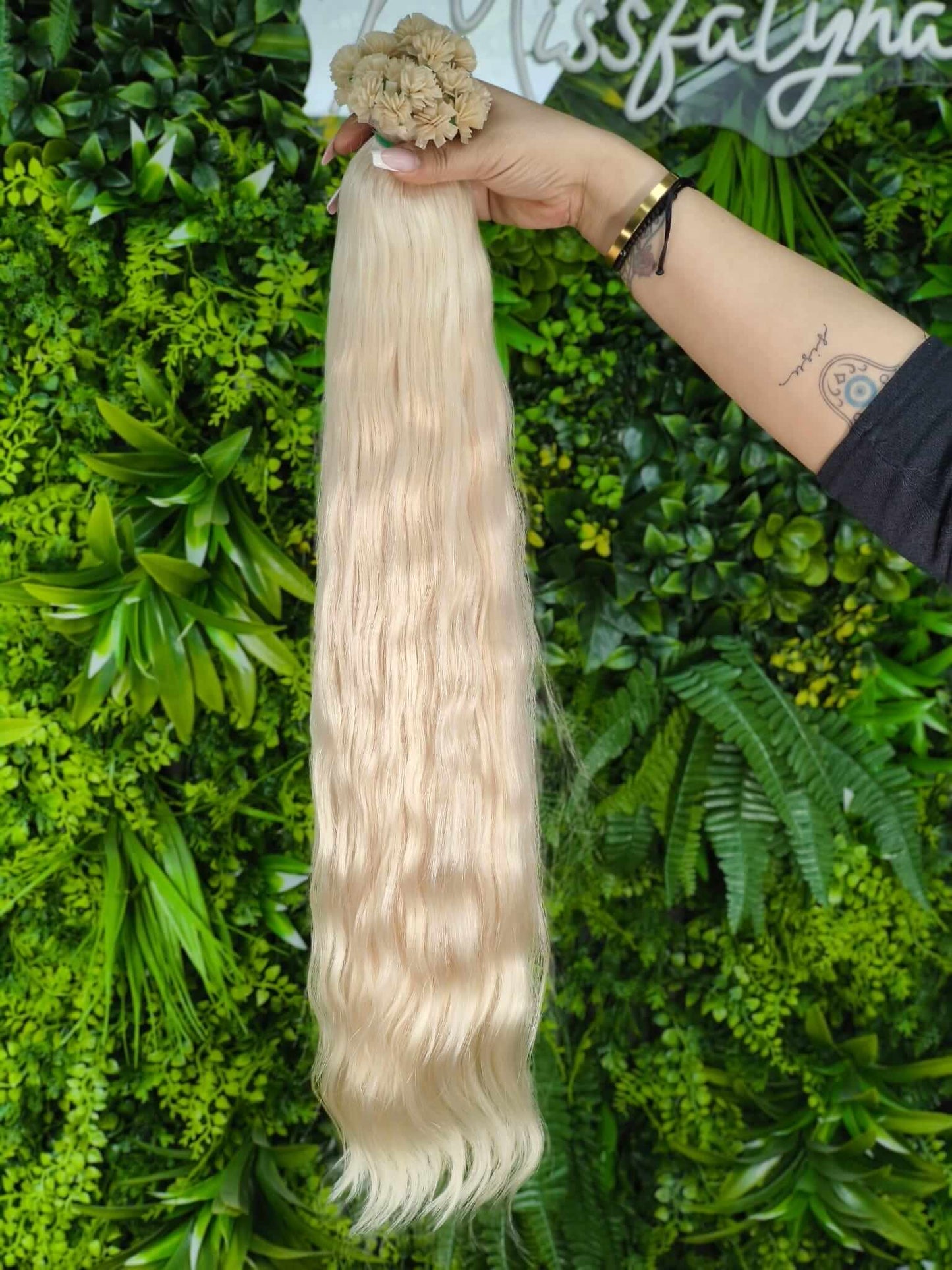 Virgin Echthaar Bondings 65 cm 210 g Platinblond wellig von Miss Faty Hair, präsentiert vor grünem Hintergrund.